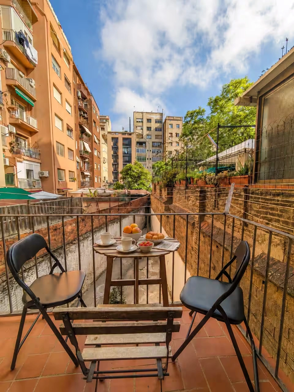 Privater Balkon mit Frühstückstisch und Blick auf einen Innenhof im Eixample